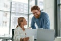 Two diverse business colleagues disscuss biz issue while use laptop in office background Royalty Free Stock Photo