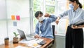 Two business colleagues greet each other by bumping elbows when meeting in office while wearing face mask Royalty Free Stock Photo