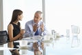 Two Business Colleagues Sitting Around Boardroom Table Having Informal Discussion Royalty Free Stock Photo