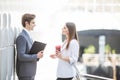 Two Business Colleagues standing in office hall having informal discussion with coffee Royalty Free Stock Photo