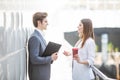 Two Business Colleagues standing in office hall having informal discussion with coffee Royalty Free Stock Photo