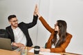 Two business executives raised up hands hitting five at the office