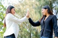 Two business girls touch their hands together or hi five in the garden with concept of the successful of work Royalty Free Stock Photo