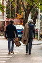 Two business man crossing the street using the pedestrian crossing in Bucharest, Romania, 2019