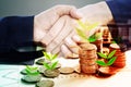 Two business man hand shake and tree growing on stack of coins success and partnership concept