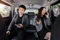 Two business man and woman using mobile phone while sitting at the back seat of car Royalty Free Stock Photo