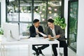 Two business men meeting to talking or discuss marketing work in workplace using paperwork, calculator, computer to work Royalty Free Stock Photo