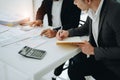 Two business men meeting to talking or discuss marketing work in workplace using paperwork, calculator, computer to work Royalty Free Stock Photo