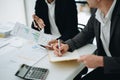 Two business men meeting to talking or discuss marketing work in workplace using paperwork, calculator, computer to work Royalty Free Stock Photo