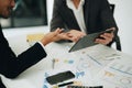 Two business men meeting to talking or discuss marketing work in workplace using paperwork, calculator, computer to work Royalty Free Stock Photo