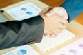 Two business men shaking hands with document background