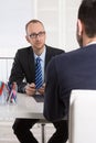 Two business men sitting in the office: meeting or job interview Royalty Free Stock Photo