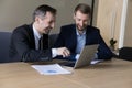 Two business partners discuss on-line project using laptop Royalty Free Stock Photo