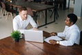 Two business partners discussing actively their startup project sitting at office desk, top view. Royalty Free Stock Photo