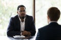 African businessman listens Caucasian partner during formal meeting in office Royalty Free Stock Photo