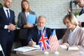 Two business partners signing a document. The United States of America and Great Britian