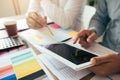 Two business partnership coworkers working on digital tablet discussing a financial planning graph and company during a budget Royalty Free Stock Photo