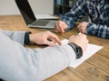 Two business people have meeting round a wooden table at an office