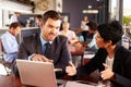 Two business people with laptop meeting in a coffee shop Royalty Free Stock Photo