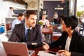 Two business people with laptop meeting in a coffee shop Royalty Free Stock Photo