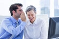 Two business people looking at a paper while working on computer Royalty Free Stock Photo