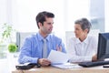 Two business people looking at a paper while working on folder Royalty Free Stock Photo