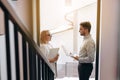 Two business people man and woman are standing opposite each other in a large corridor and talking. Concept of successful business Royalty Free Stock Photo