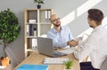 Two business people in office making deal. Two men shaking hands celebrating business achievement. Royalty Free Stock Photo