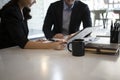 Two businesspeople sitting in modern office and checking financial reports together. Royalty Free Stock Photo