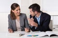 Two business people sitting in the office talking and analyzing