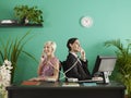 Two business people talking on entangled phones in office Royalty Free Stock Photo