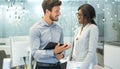 Two business people talking and smiling to each other in modern office. Royalty Free Stock Photo