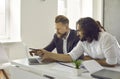 Two business people working on laptop, doing research and discussing marketing strategy Royalty Free Stock Photo