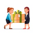 Two business woman carrying big holiday gift box Royalty Free Stock Photo