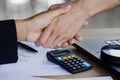 Two business woman handshake after working together and agree on their project at office with some financial paper graph Royalty Free Stock Photo