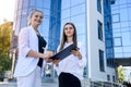 Two business women signing contract outdoors before building of big office center Royalty Free Stock Photo