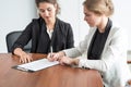 Two business women signing a document Royalty Free Stock Photo