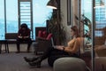 Two business women sitingt in a modern coworking space on a break from work and relax using a laptop. Selective focus Royalty Free Stock Photo