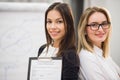 Two business women standing at office in front of flip chart Royalty Free Stock Photo