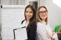 Two business women standing at office in front of flip chart Royalty Free Stock Photo