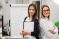 Two business women standing at office in front of flip chart Royalty Free Stock Photo