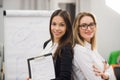 Two business women standing at office in front of flip chart Royalty Free Stock Photo