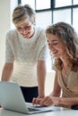 two business women using laptop computer working in office team leader sharing ideas with colleague on screen Royalty Free Stock Photo