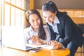 Two business women are working on a notebook computer, holding a Royalty Free Stock Photo