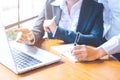 Two business women working in a notebook computer and writing on Royalty Free Stock Photo