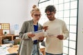 Two business workers concentrated reading paperwork standing at the office