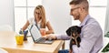 Two business workers smiling happy working with dog at the office Royalty Free Stock Photo