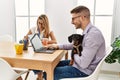 Two business workers smiling happy working with dog at the office Royalty Free Stock Photo