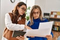 Two business workers woman reading paperwork using touchpad at the office Royalty Free Stock Photo