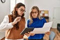 Two business workers woman reading paperwork using touchpad at the office Royalty Free Stock Photo